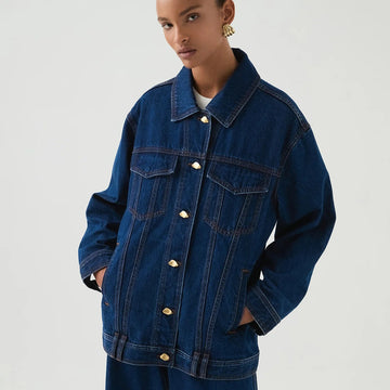 Person wearing a blue denim jacket on a white background