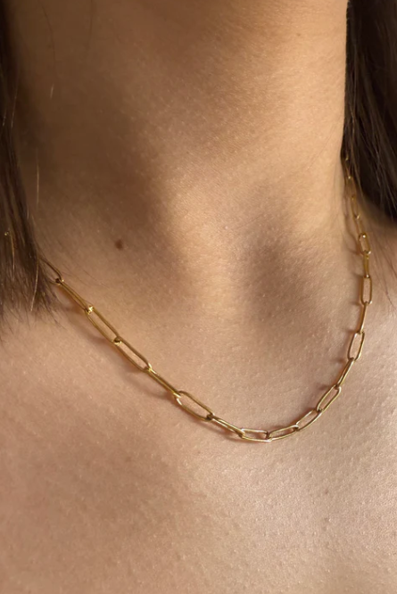 Gold chain necklace on a person's neck