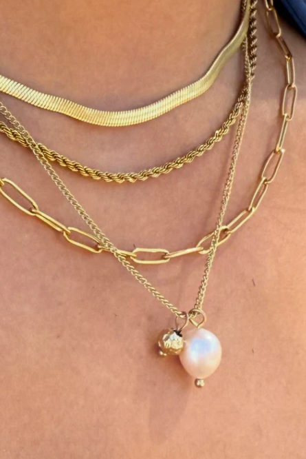 Gold chain necklace on a person's neck