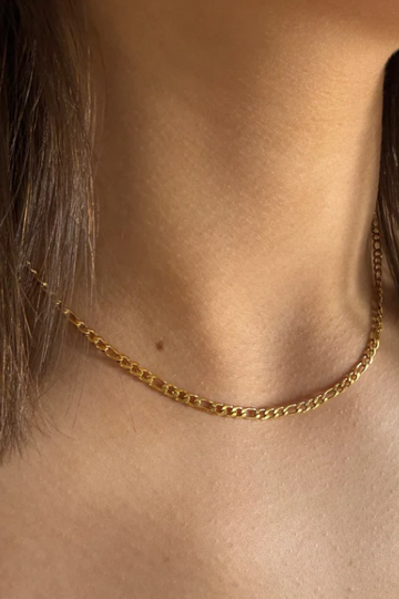 Gold chain necklace worn by a person with short hair
