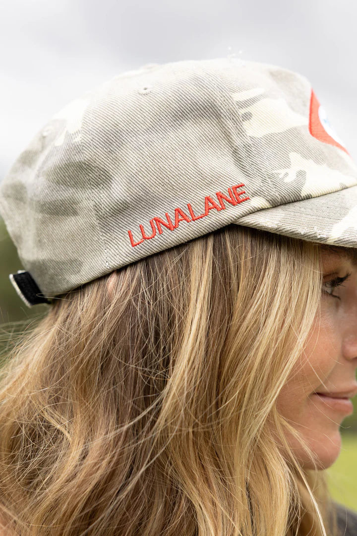 Person wearing a cap with 'LUNALANE' branding, blurred background
