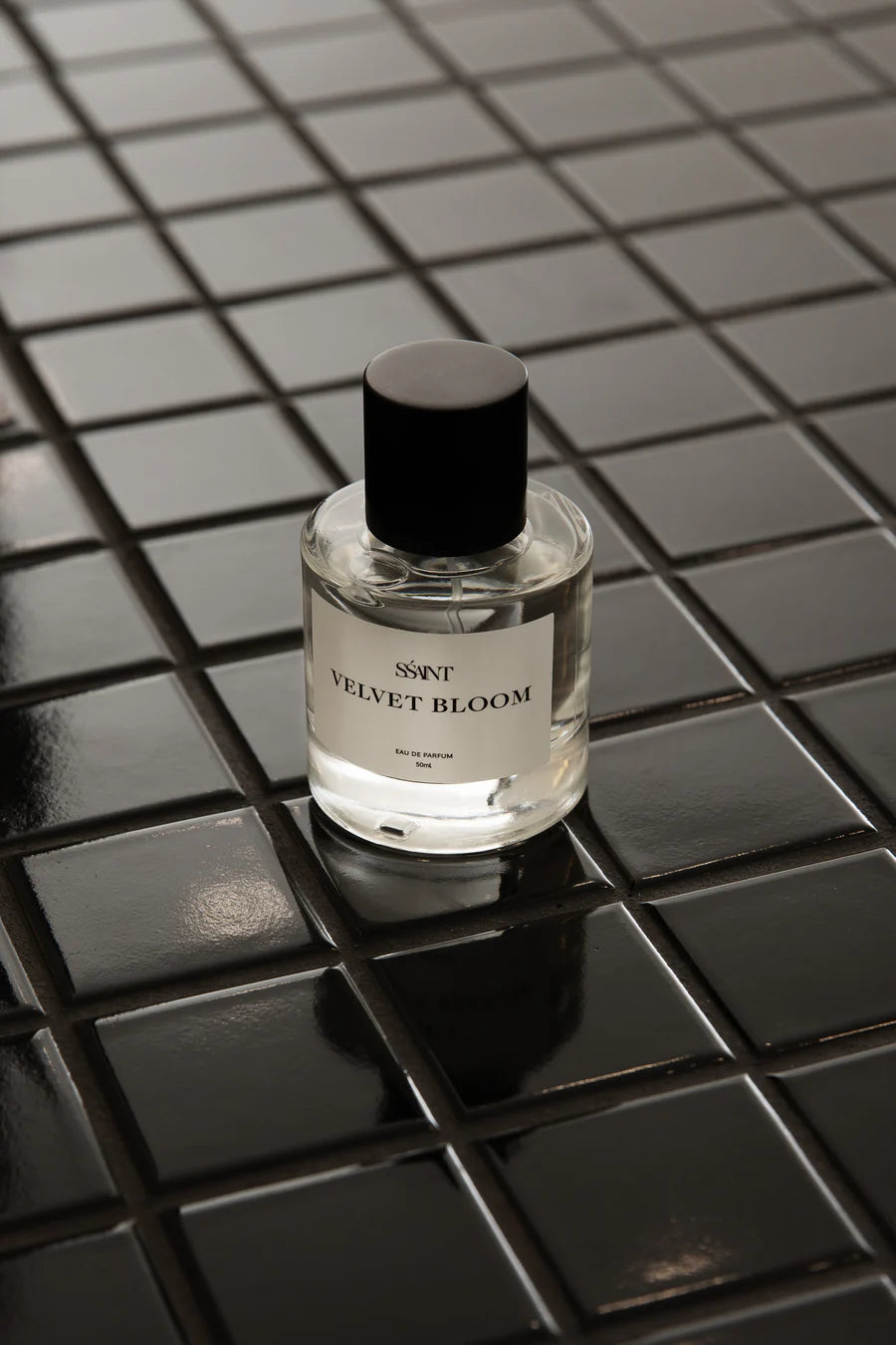 Bottle of Scented World 'Velvet Bloom' on a black tiled surface