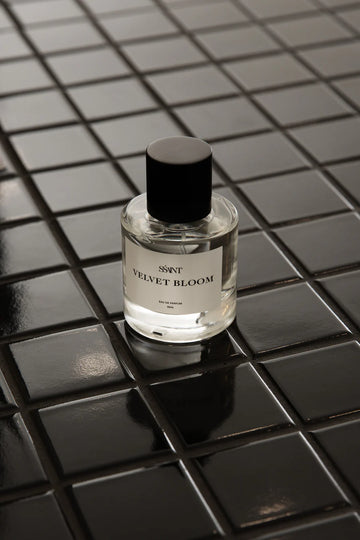 Bottle of Scented World 'Velvet Bloom' on a black tiled surface