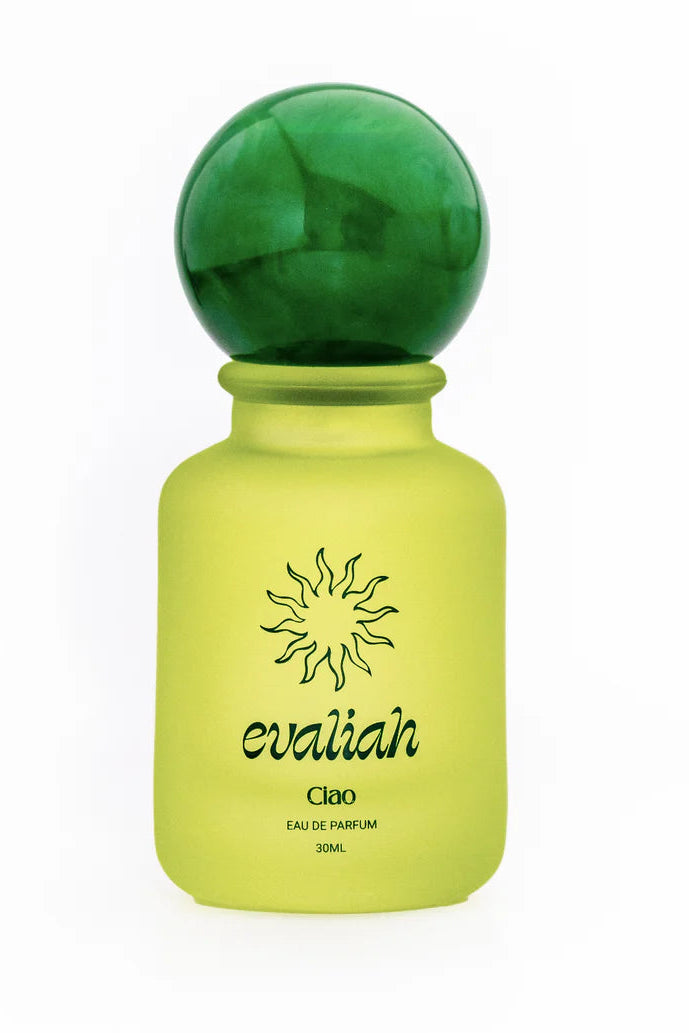 Yellow perfume bottle with green cap on a white background