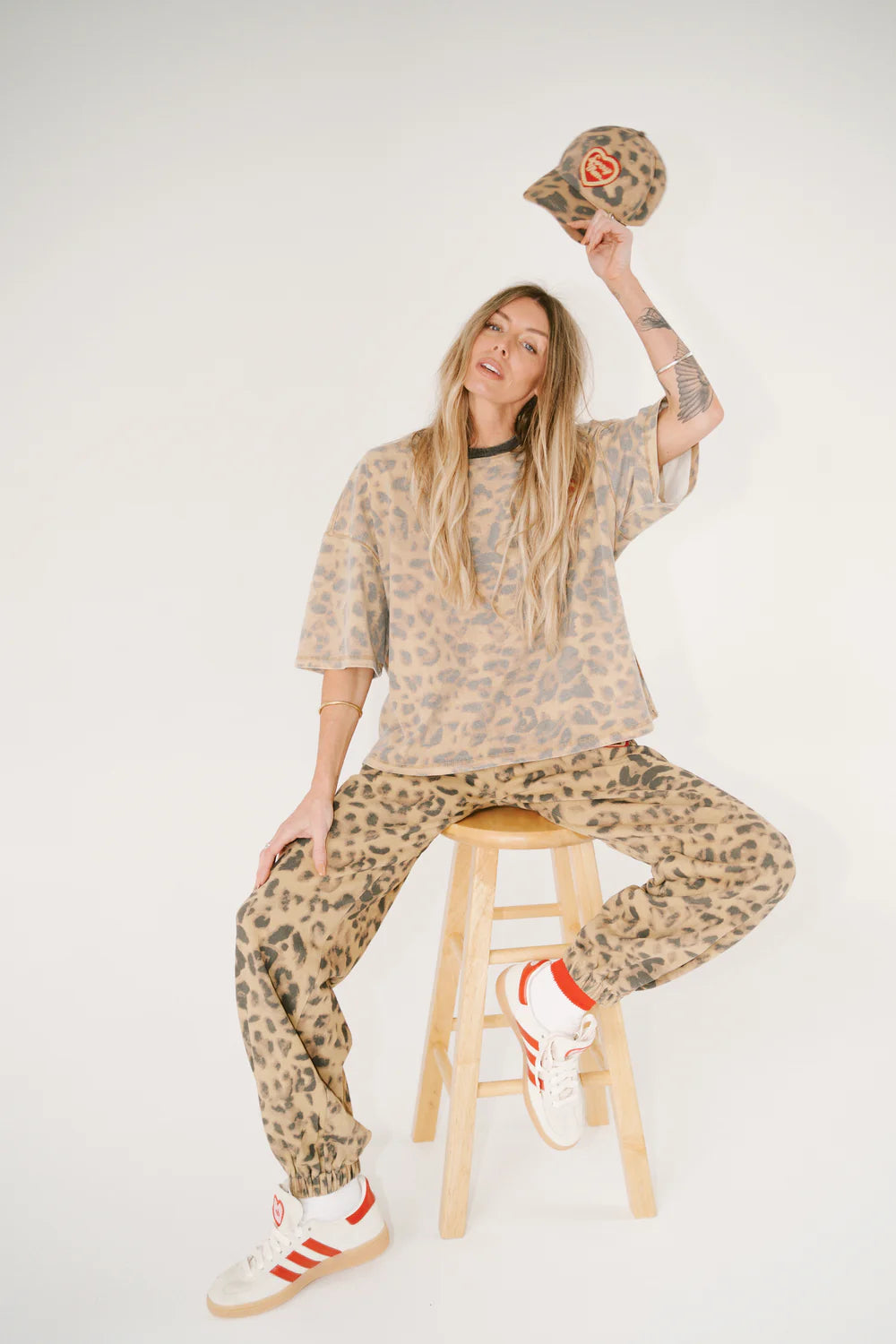 Person wearing a leopard print outfit with a graphic t-shirt on a white background