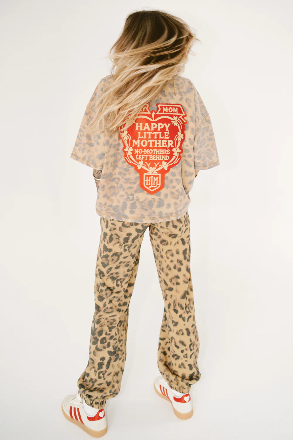 Person wearing a leopard print outfit with a graphic t-shirt on a white background