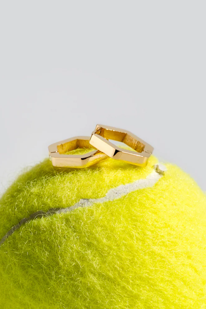 Gold hoop earring worn by a person with blonde hair.